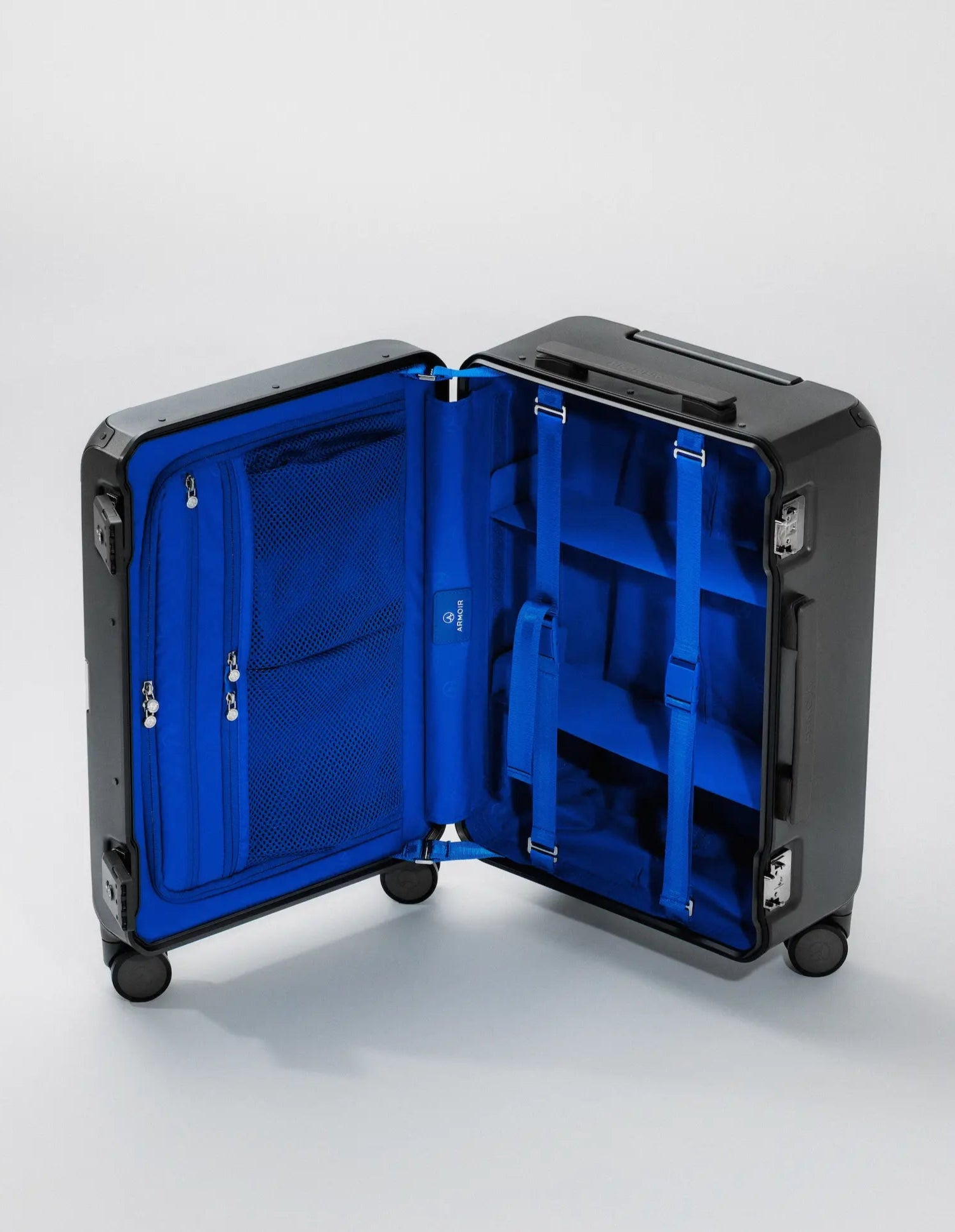 Armoir carry-on trunk open to reveal bright blue interior with compression dividers and mesh pockets