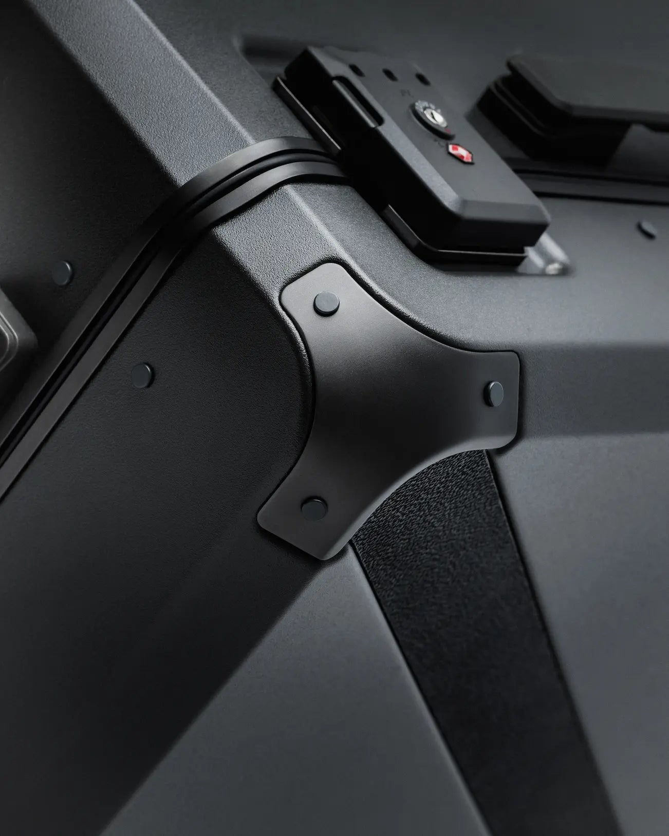 Detail of Armoir carry-on trunk showing reinforced aluminum corner and TSA-approved lock